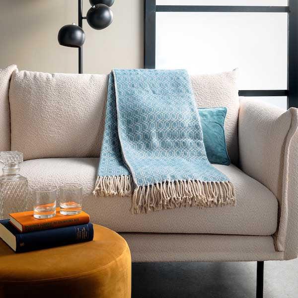 Plaid Elodie sagebrush green 180x140cm op de bank